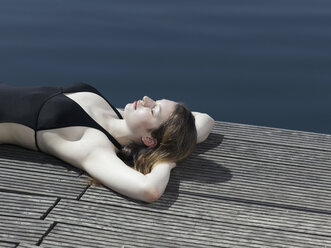 A woman in a swimsuit lying on a jetty - FSIF02562