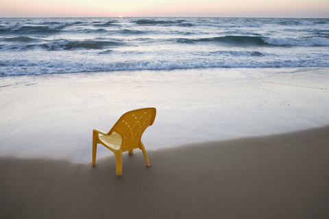 Ein Plastikstuhl am Strand, lizenzfreies Stockfoto