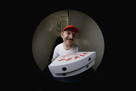 A pizza delivery man, viewed through peephole stock photo