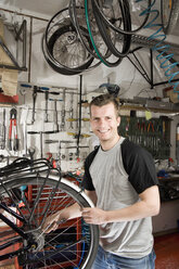 Ein Mann repariert ein Fahrrad in einer Werkstatt - FSIF02609