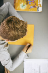 Schoolboy writing on desk in class - ZEDF01190