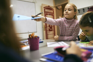 Schülerin, die einem Mitschüler in der Klasse ein Blatt Papier übergibt - ZEDF01216