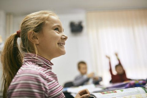 Porträt einer lächelnden Schülerin im Unterricht, lizenzfreies Stockfoto