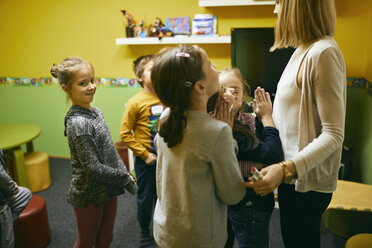 Teacher standing with students in class - ZEDF01222