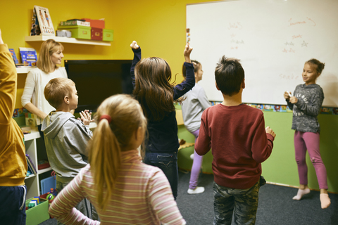 Lehrer mit Schülern im Entspannungsraum mit Whiteboard, lizenzfreies Stockfoto