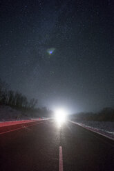 Russland, Oblast Amur, leere Landstraße unter Sternenhimmel im Winter - VPIF00320