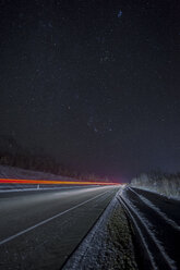 Russland, Oblast Amur, leere Landstraße unter Sternenhimmel im Winter - VPIF00321