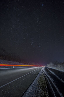 Russland, Oblast Amur, leere Landstraße unter Sternenhimmel im Winter - VPIF00321