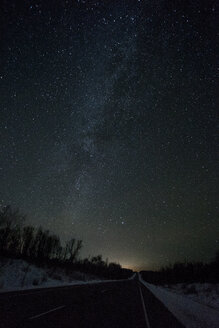 Russland, Oblast Amur, leere Landstraße unter Sternenhimmel im Winter - VPIF00322