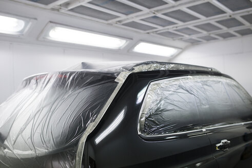 Car inside a paint booth in a repair garage - RAEF01969