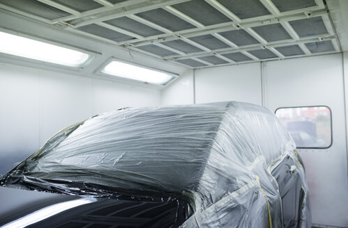 Car inside a paint booth in a repair garage - RAEF01970