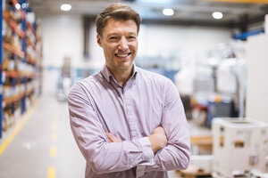 Porträt eines lächelnden Geschäftsmannes in einer Fabrik - DIGF03404