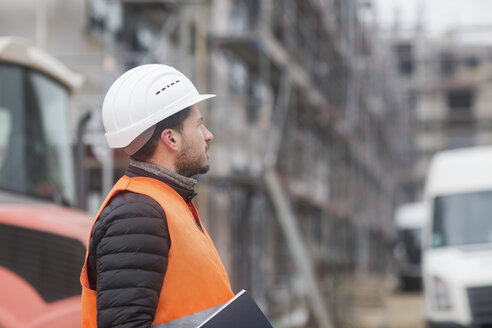 Mann mit Sicherheitsweste und Helm auf einer Baustelle - SGF02189