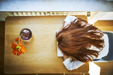 Redheaded woman resting at table with laptop, top view - FMKF04871