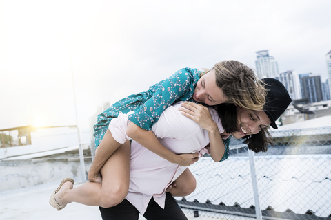 Young affectionate couple having fun together on rooftop stock photo