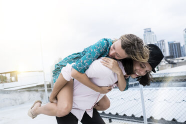 Young affectionate couple having fun together on rooftop - SBOF01382