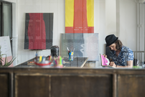 Artist at work, drawing in a notebook in his loft studio stock photo