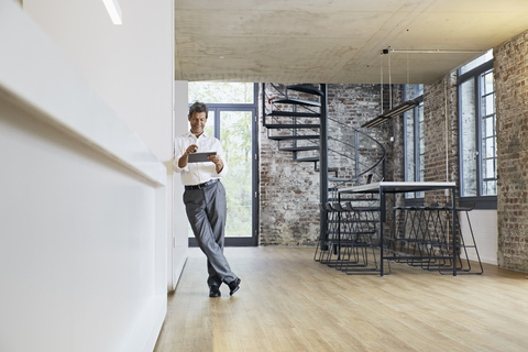 Businessman in modern office using tablet stock photo