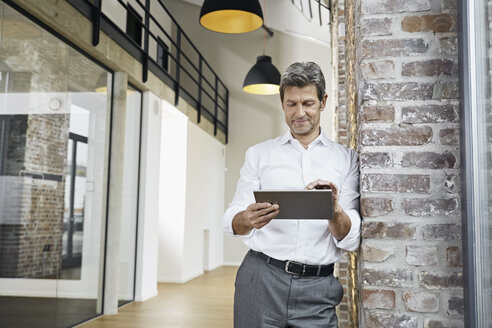 Portrait of mature businessman using tablet in modern office - PDF01470