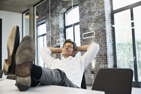 Mature businessman relaxing in conference room of modern office - PDF01505