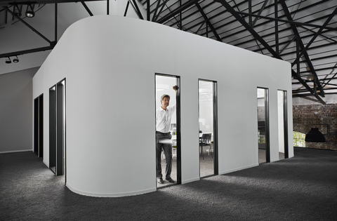 Businessman in modern conference room looking out of window stock photo