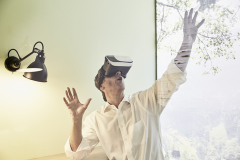Aufgeregter Geschäftsmann mit VR-Brille, lizenzfreies Stockfoto
