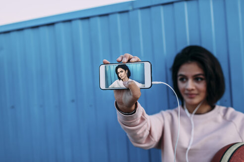 Junge Frau mit Basketball zeigt ein Selfie am Container - VPIF00343