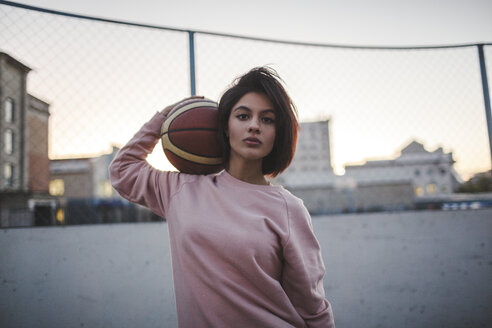 Porträt einer jungen Frau, die einen Basketball im Freien hält - VPIF00346
