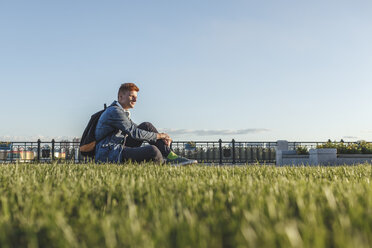 Young man sitting on a meadow - VPIF00371