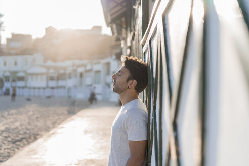 Young man relaxing on the beach at sunset - AFVF00141