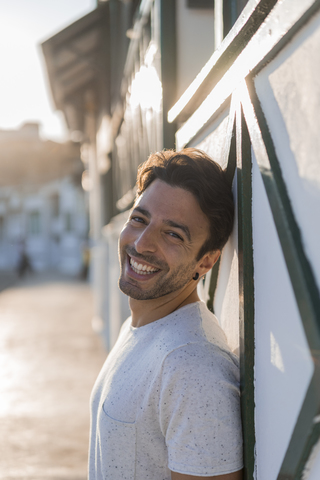 Portrait of laughing young man relaxing on the beach at sunset stock photo