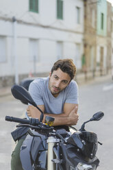 Portrait of young man sitting on motorbike - AFVF00154