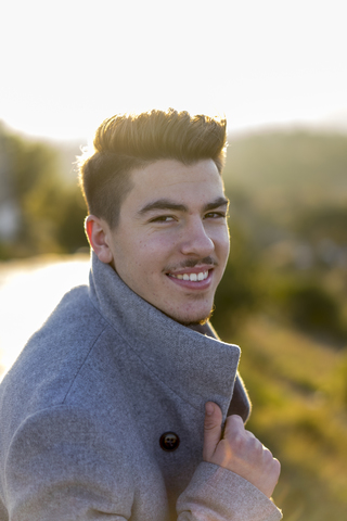 Portrait of smiling young man at twilight stock photo