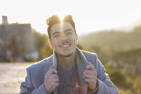 Portrait of smiling young man at twilight stock photo