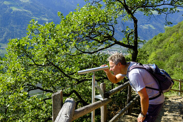 Italien, Südtirol, Vinschgau, Naturns, Sonnenberg Panoramaweg, Wanderer schaut durchs Fernrohr - LBF01781