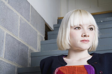 Eine junge Frau sitzt auf einer Treppe - FSIF02649