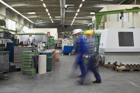Zwei Arbeiter gehen durch eine Fabrik, unscharfe Bewegung, Langzeitbelichtung - FSIF02665