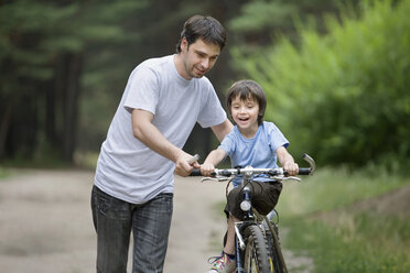 Ein Vater bringt seinem Sohn das Fahrradfahren bei - FSIF02699