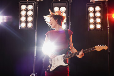 A woman playing electric guitar performing on stage - FSIF02759