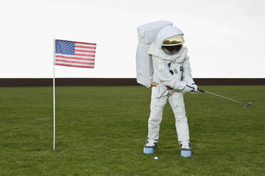 Ein Astronaut, der neben einer amerikanischen Flagge einen Golfschläger schwingt - FSIF02761