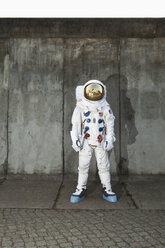 Ein Astronaut, der auf einem Bürgersteig in einer Stadt steht - FSIF02771