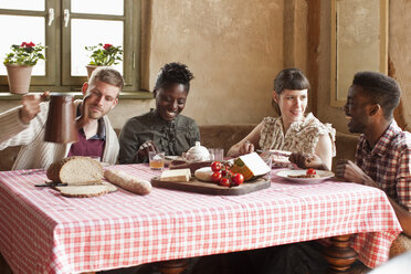 Two couples enjoying a simple rustic meal - FSIF02779