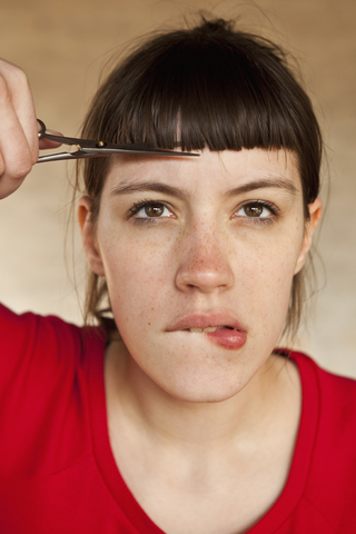 A woman trimming her own bangs stock photo