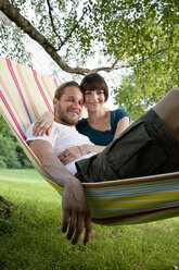 A young happy couple lying in a hammock together - FSIF02792