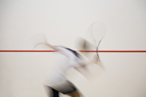 A man playing squash, blurred motion stock photo
