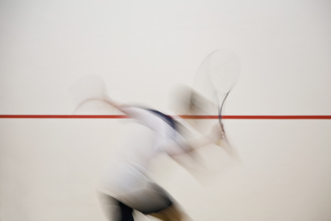 Ein Mann spielt Squash, unscharfe Bewegung, lizenzfreies Stockfoto