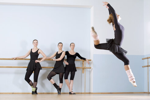 Eine Ballerina springt durch die Luft, während drei andere Frauen zusehen - FSIF02801