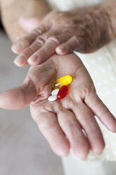 Detail von Kapseln und Tabletten in den Händen einer älteren Frau - FSIF02867