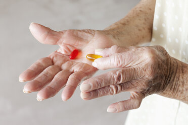 Detail of capsules in the hands of a senior woman - FSIF02869