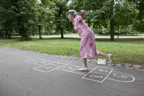 Senior woman playing hopscotch stock photo